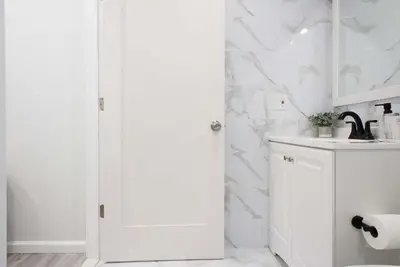 a white bathroom with a toilet and a sink at 240-15 Luxury Studio Prime Location W&D in New York