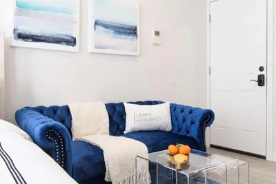 a blue couch in a living room with a glass table at 240-15 Luxury Studio Prime Location W&D in New York