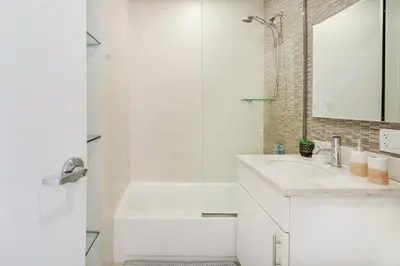 a white bathroom with a sink and a shower at 809-5A Gorgeous New 1BR Heart of Midtown in New York