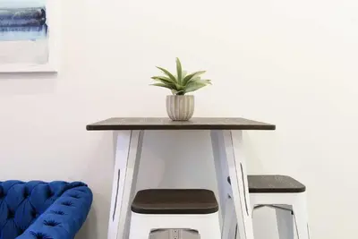 a table with a potted plant on it next to two stools at 240-5 NEW Prime Location STUDIO W&D in unit in New York