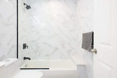 a white bathroom with a sink and a toilet at 240-5 NEW Prime Location STUDIO W&D in unit in New York