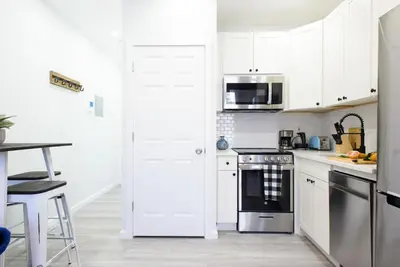 a kitchen with white cabinets and a stove top oven at 240-5 NEW Prime Location STUDIO W&D in unit in New York