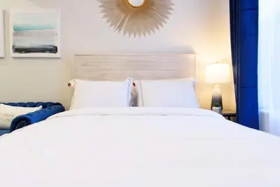 a bedroom with a large white bed and a mirror at 240-6 NEW STUDIO Prime Location W&D in unit in New York