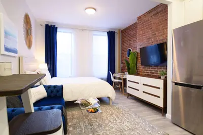 a hotel room with a bedroom with a bed and a tv at 240-6 NEW STUDIO Prime Location W&D in unit in New York