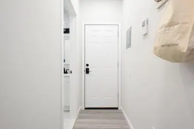 a hallway with white walls and a white door at 240-6 NEW STUDIO Prime Location W&D in unit in New York