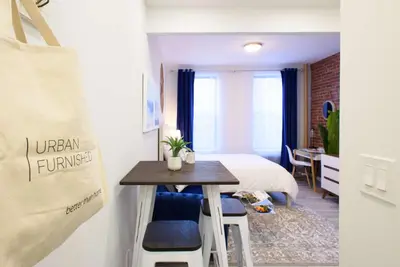 a small room with a bed and a table and a room with a bed at 240-6 NEW STUDIO Prime Location W&D in unit in New York