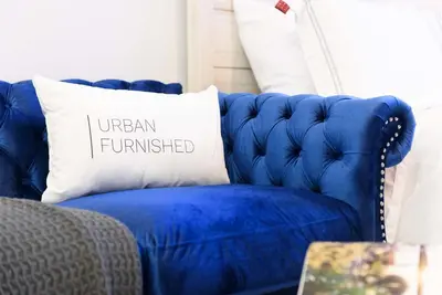 a blue couch with a pillow that reads urban furnished at 240-6 NEW STUDIO Prime Location W&D in unit in New York