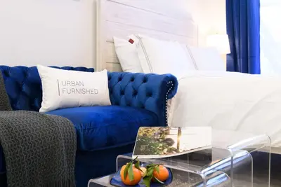 a living room with a blue couch and a table at 240-6 NEW STUDIO Prime Location W&D in unit in New York