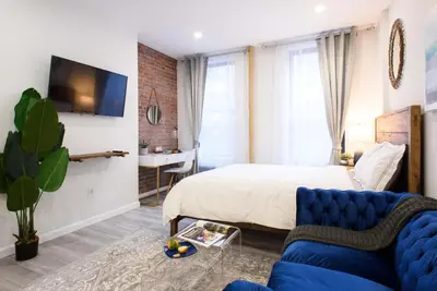 a bedroom with a bed and a blue couch at 240-9 Luxury Prime Location STUDIO W&D in New York