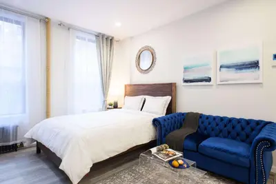a bedroom with a bed and a blue couch at 240-9 Luxury Prime Location STUDIO W&D in New York