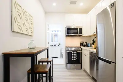 a kitchen with white cabinets and a table and a refrigerator at 240-9 Luxury Prime Location STUDIO W&D in New York