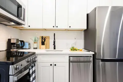 a kitchen with white cabinets and a stainless steel refrigerator at 240-9 Luxury Prime Location STUDIO W&D in New York