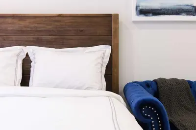 a bed with white pillows and a wooden headboard at 240-9 Luxury Prime Location STUDIO W&D in New York