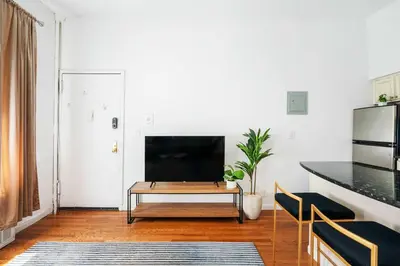 a living room with a tv and a table at 26-2B Gramercy Large 1BR WD in unit courtyard in New York