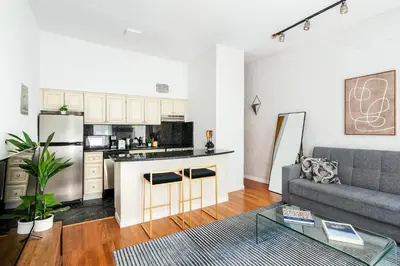 a living room with a couch and a kitchen at 26-2B Gramercy Large 1BR WD in unit courtyard in New York