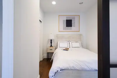 a bedroom with a white bed and a picture on the wall at 69-5A Modern Lower East Side 1BR Apt BRAND NEW in New York