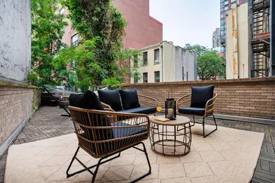 a patio with chairs and a couch and a table at 809-2B New bldg Jr columbus circle Balcony WD in New York