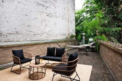 a patio with chairs and tables and a brick wall at 809-2B New bldg Jr columbus circle Balcony WD in New York