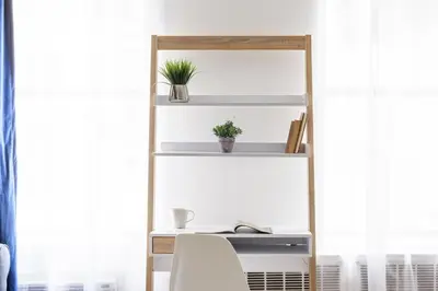 a desk with a computer and a shelf with plants at 26-4B Newly Furnished 1BR W D Courtyard in New York