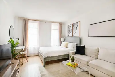 a white living room with a bed and a couch at 1597-10 New Studio Upper East Side W&D in unit in New York