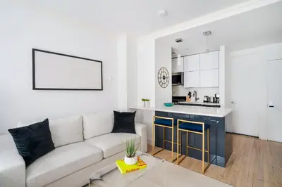 a living room with a couch and a kitchen at 1597-10 New Studio Upper East Side W&D in unit in New York