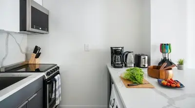 a kitchen counter with vegetables on a cutting board at 1597-11 Studio - Upper East Side Apt W&D in New York