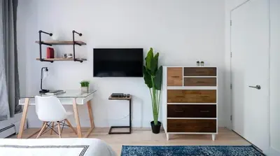 a living room with a desk and a tv on a wall at 1597-11 Studio - Upper East Side Apt W&D in New York