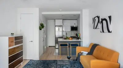 a living room with a couch and a kitchen at 1597-11 Studio - Upper East Side Apt W&D in New York