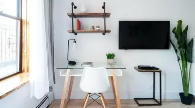 a desk with a white chair and a television on a wall at 1597-11 Studio - Upper East Side Apt W&D in New York