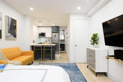 a living room with a bed and a kitchen at 1597-12 NEW Studio Prime UES WD in unit in New York