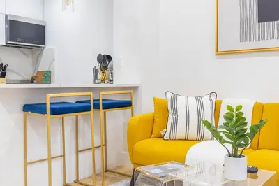 a living room with a yellow couch and a table at 1597-13 I Brand new Studio Prime upper east W&D in New York