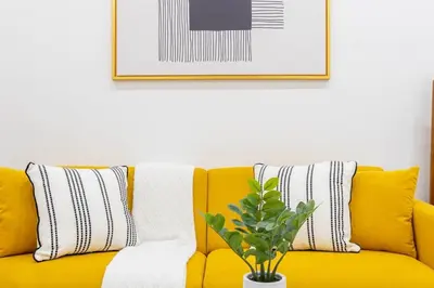 a yellow couch with pillows and a plant on it at 1597-13 I Brand new Studio Prime upper east W&D in New York