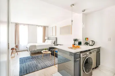 a kitchen and living room with a washing machine at 1597-14 New Renovated Studio rime UES - W D in New York