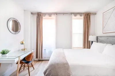 a bedroom with a bed and a desk and windows at 1597-14 New Renovated Studio rime UES - W D in New York