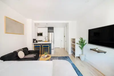 a white living room with a couch and a tv at 1597-14 New Renovated Studio rime UES - W D in New York