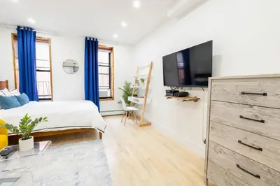 a bedroom with a bed and a tv on a wall at 1597-1 Large studio W D in the unit prime UES in New York