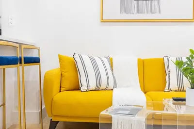 a yellow couch in a living room with a table at 1597-1 Large studio W D in the unit prime UES in New York