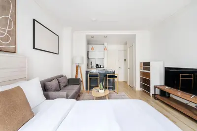 a bedroom with a bed and a living room at 1597-2 Luxury Upper East Side Studio W&D in New York