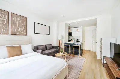 a bedroom with a bed and a living room at 1597-2 Luxury Upper East Side Studio W&D in New York