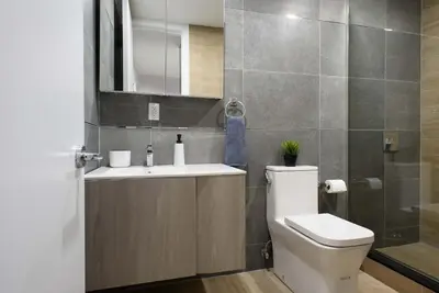 a bathroom with a toilet and a sink and a mirror at 1597-3 Studio Upper East Side Apt W&D in unit in New York
