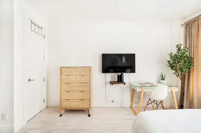a white bedroom with a television and a desk at 1597-4 Brand new Prime UES W D walk to C park in New York
