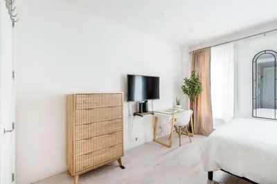 a white bedroom with a bed and a tv on a wall at 1597-4 Brand new Prime UES W D walk to C park in New York