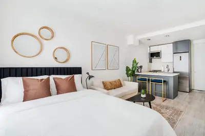 a bedroom with a white bed and a kitchen at 1597-4 Brand new Prime UES W D walk to C park in New York