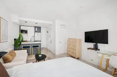 a living room with a white couch and a kitchen at 1597-4 Brand new Prime UES W D walk to C park in New York
