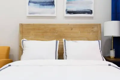 a bedroom with two white beds and a wooden headboard at 1597-5 New Studio Prime UES W D in unit in New York