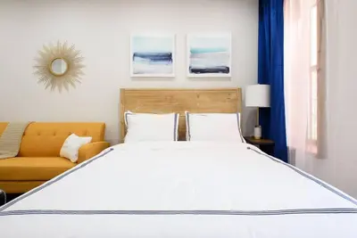 a bedroom with a large white bed and a couch at 1597-5 New Studio Prime UES W D in unit in New York