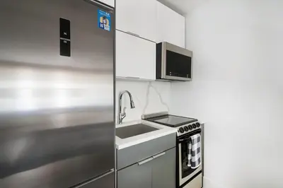 a kitchen with a sink and a microwave at 1597-7 Luxury Upper East Studio W&D in unit in New York
