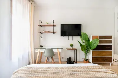 a bedroom with a bed and a desk and a tv at 1597-7 Luxury Upper East Studio W&D in unit in New York