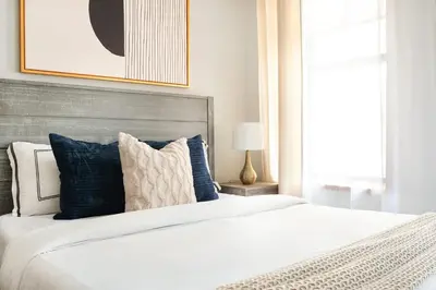 a bedroom with a large white bed with blue pillows at 1597-7 Luxury Upper East Studio W&D in unit in New York