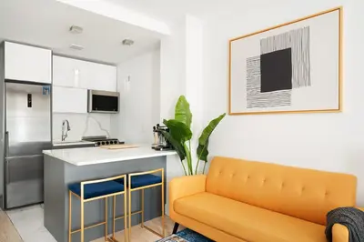 a living room with a couch and a kitchen at 1597-7 Luxury Upper East Studio W&D in unit in New York